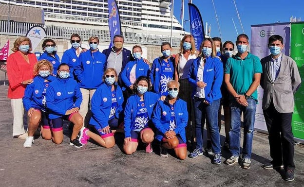 Mujeres supervivientes de un cáncer de mama reciben de la AECC de Málaga ropa para practicar piragüismo