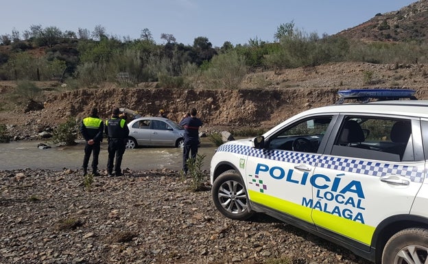 Un conductor es arrastrado por la corriente en el río Campanillas tras la apertura de la presa Casasola