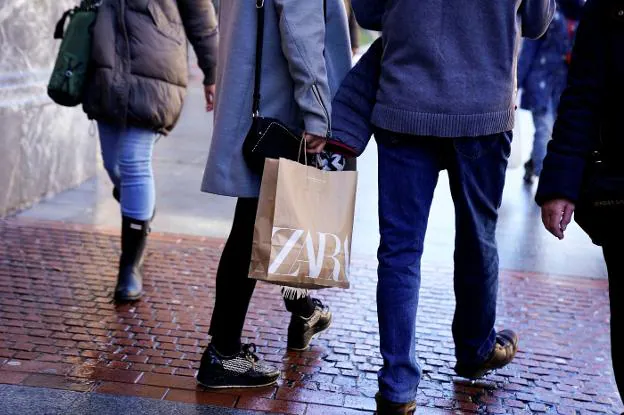 Unos ciudadanos pasean con bolsas de Zara. reuters/