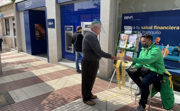 Un vendedor de la Once ayuda a sus vecinos a usar el cajero automático en Marbella