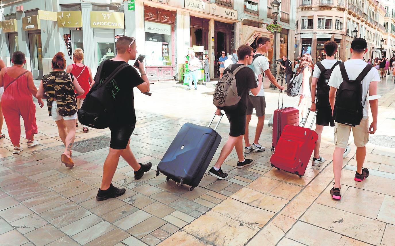 Un grupo de turistas se desplaza por la calle Larios, en Málaga capital, en busca de su alojamiento. /Salvador Salas