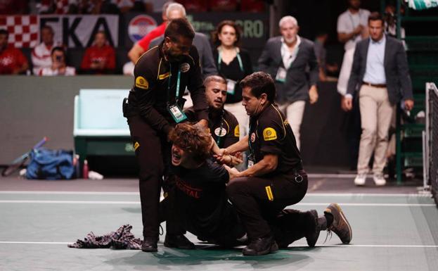 Dos activistas tratan de encadenarse a la red de la pista en un intermedio de la Copa Davis en Málaga