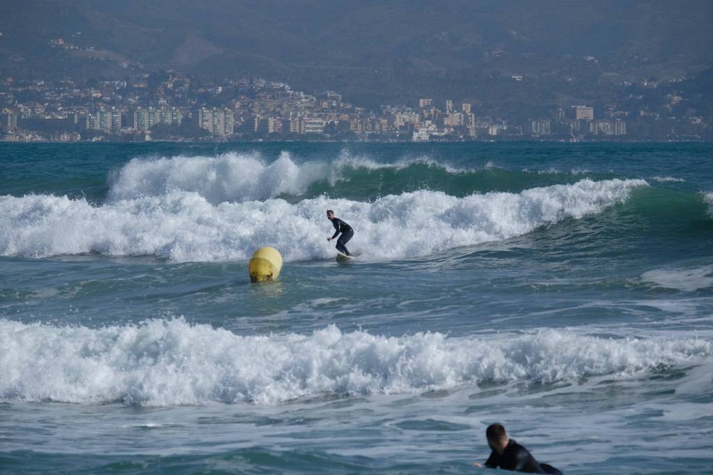 Surferos aprovechan el viento de levante y las olas del temporal en Málaga